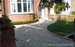 AFTER: Driveway constructed using Tegula paving with sweeping curved path to front door and feature band across drive mouth, new wall, lawn and planting installed.